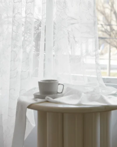 Leaf sheer curtain with morning light and tea cup on table