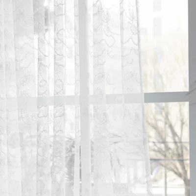 Leaf texture sheer curtain softly filtering light near a window, showing delicate botanical pattern and natural privacy effect