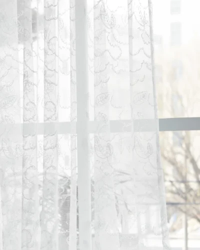 Leaf texture sheer curtain softly filtering light near a window, showing delicate botanical pattern and natural privacy effect