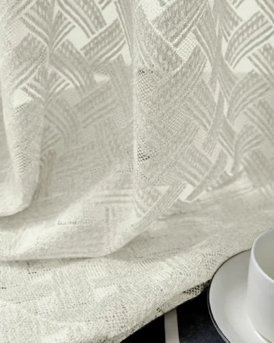 Close-up of Serene Weave Sheer Curtain fabric with soft jacquard texture and tableware