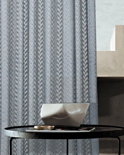 Zigzag sheer curtain hanging beside a staircase and round table