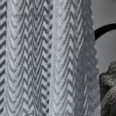 Zigzag sheer curtains hanging in a modern room, textured light voile in soft gray tones