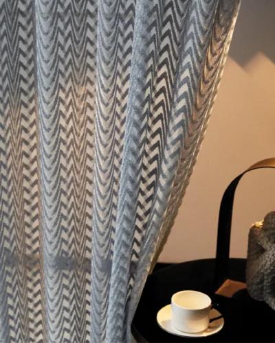 Zigzag sheer curtain with soft sunlight beside a cozy corner