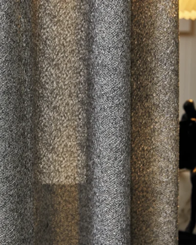 Lightflow lace curtain with subtle ripple texture, styled in a softly lit modern room.