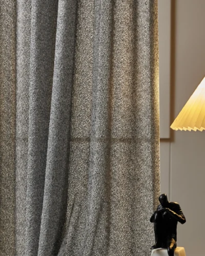 Lightflow lace curtain with textured weave, softly glowing under warm indoor lighting.