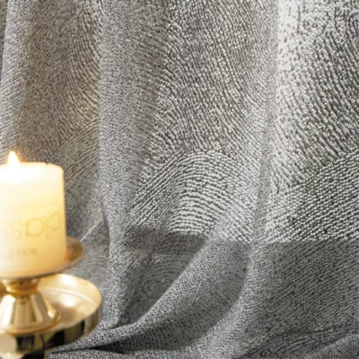 Ripple textured sheer curtain illuminated by warm candlelight, showing soft wave patterns.