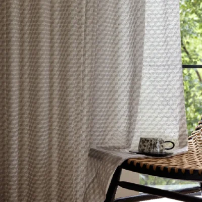 Warm beige jacquard sheer curtain with geometric pattern in a cozy modern interior