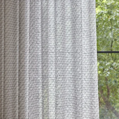 Jacquard sheer curtain filtering natural light with soft geometric texture
