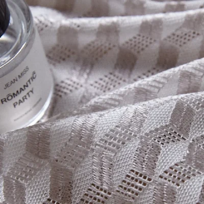 Close-up of geometric jacquard curtain fabric with fragrance bottle
