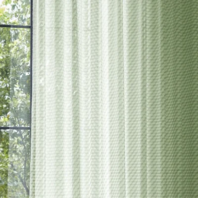 Green geometric sheer curtain filtering natural light by the window