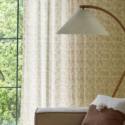 Light-filtering jacquard sheer curtain in a neutral tone, styled in a cozy bedroom setting.