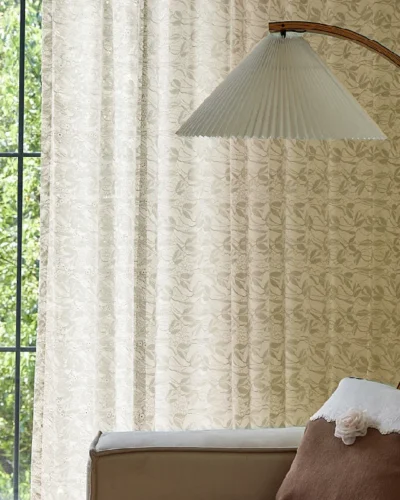 Light-filtering jacquard sheer curtain in a neutral tone, styled in a cozy bedroom setting.