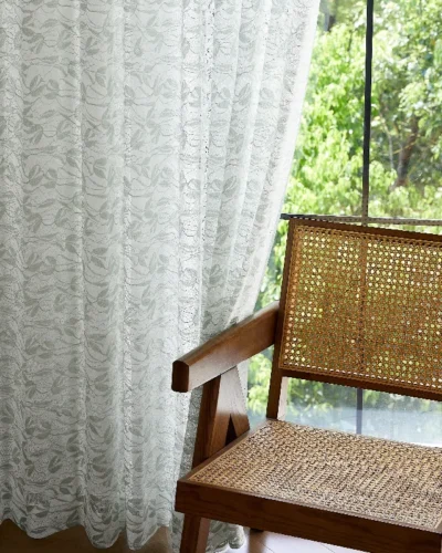 Willow Whisper Curtain hanging beside a rattan chair with natural light.