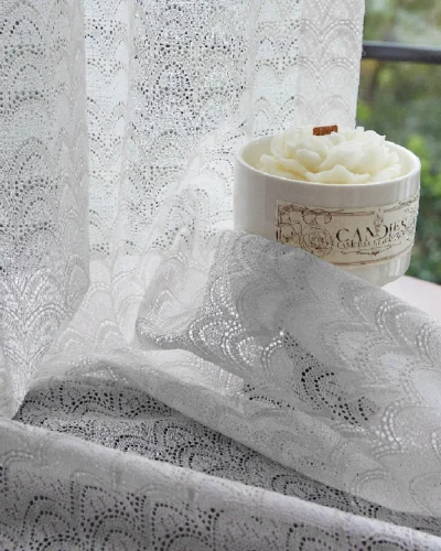 White jacquard sheer curtain with feather wave pattern near window and candle