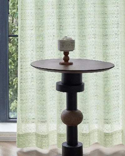 Light green jacquard sheer curtain with geometric botanical patterns by the window