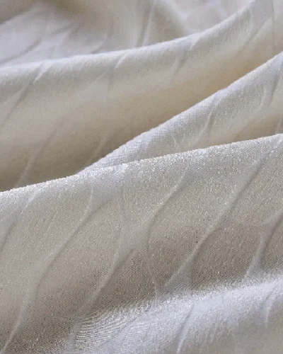 Close-up of Echo Leaf curtain fabric showing layered jacquard texture