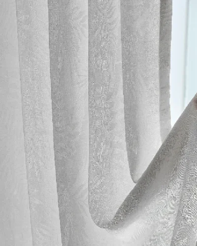 Botanic jacquard sheer curtain gently held by hand with daylight in the background