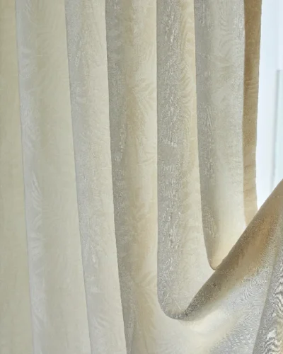 Close-up of botanical jacquard sheer curtain softly draping with filtered sunlight
