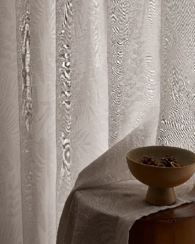 Sheer jacquard curtain with soft botanical texture beside wooden decor