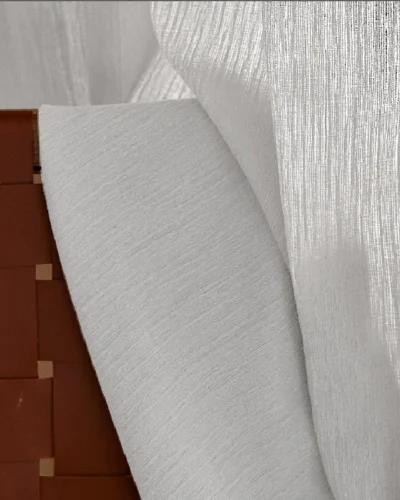 Soft chenille sheer curtain with a textured drape hanging in a cozy, modern space