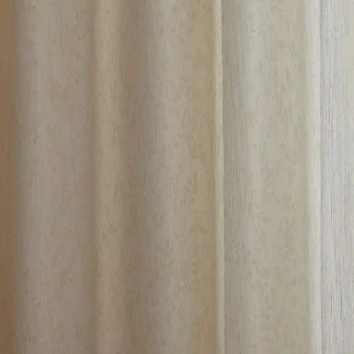 Botanical jacquard sheer curtain resting over a woven rattan chair