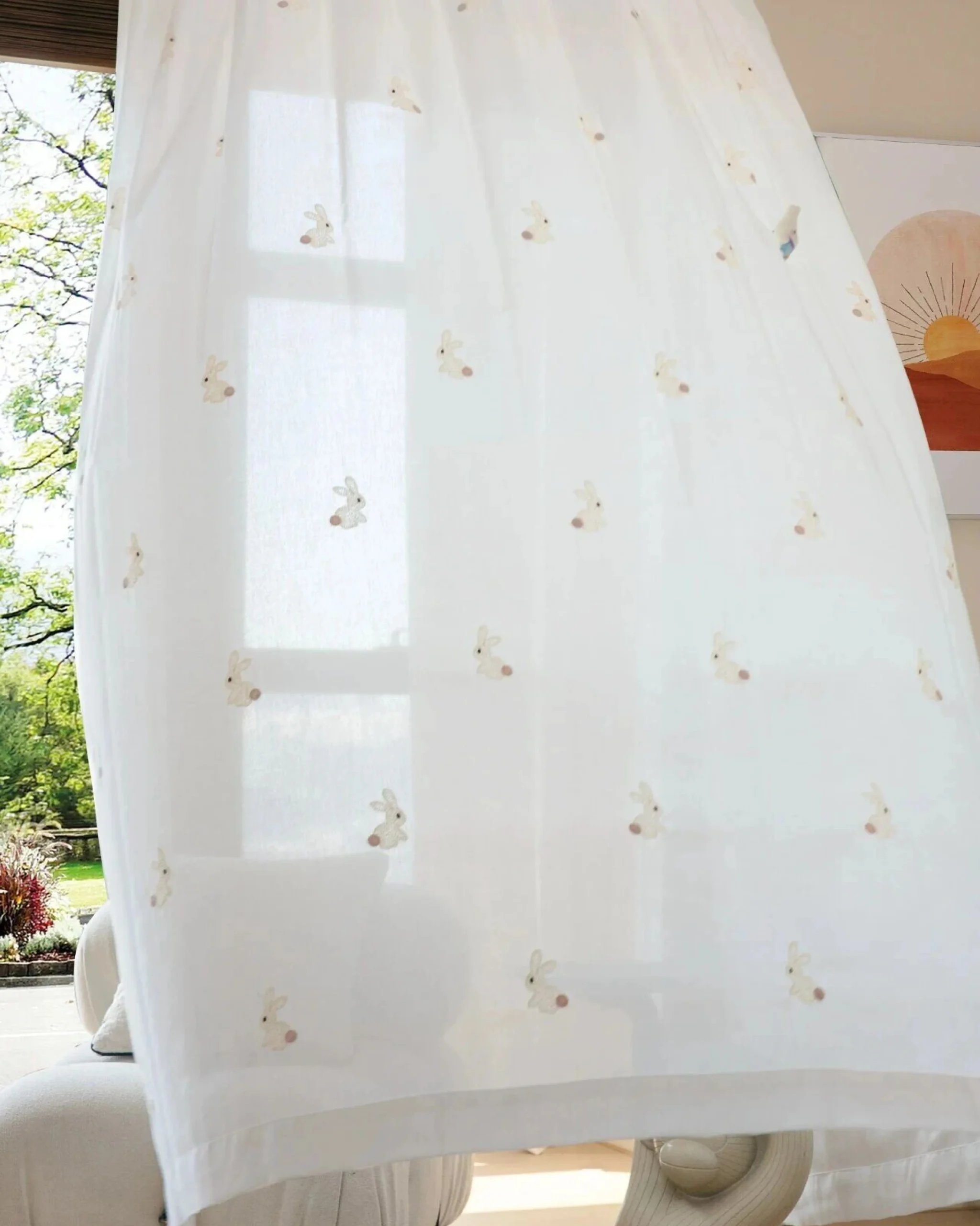 Bunny Tail sheer curtain with scattered embroidered cream rabbits hanging at a kids room window