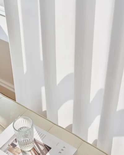 Soft white herringbone sheer curtain casting gentle shadows on the window sill.