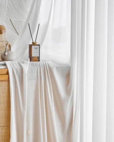 Fine Ridge Texture Curtain in soft matte ivory draped beside a wooden cabinet with a reed diffuser, hanging in a bright room.