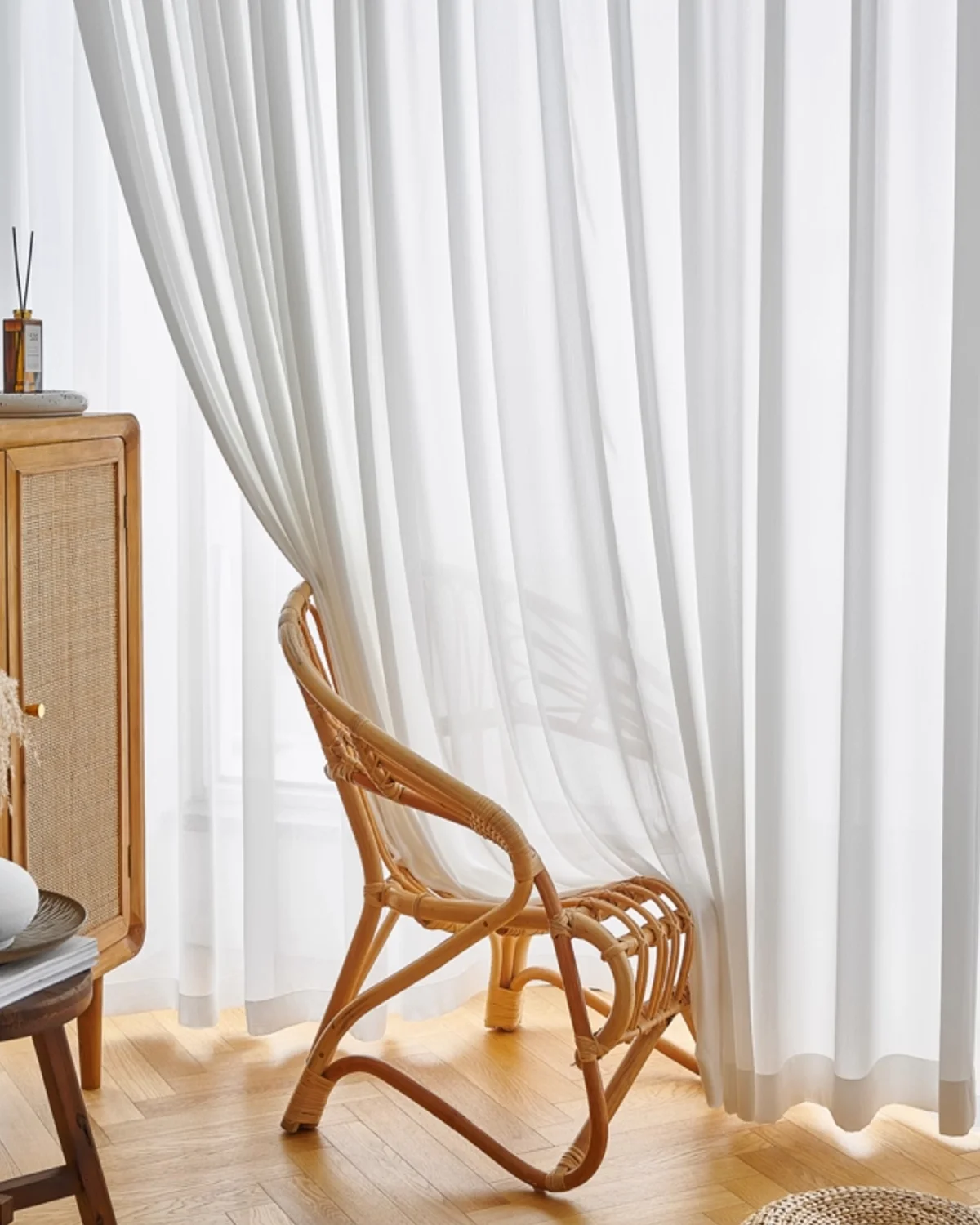Fine Ridge Texture Curtain in soft matte ivory hanging behind a rattan chair in a bright living room.