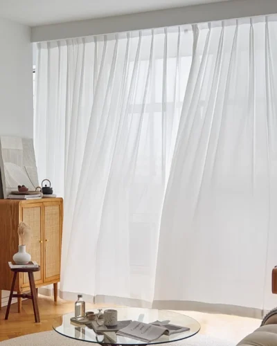 Fine Ridge Texture Curtain in soft matte ivory billowing gently by an open living room window beside a low coffee table.
