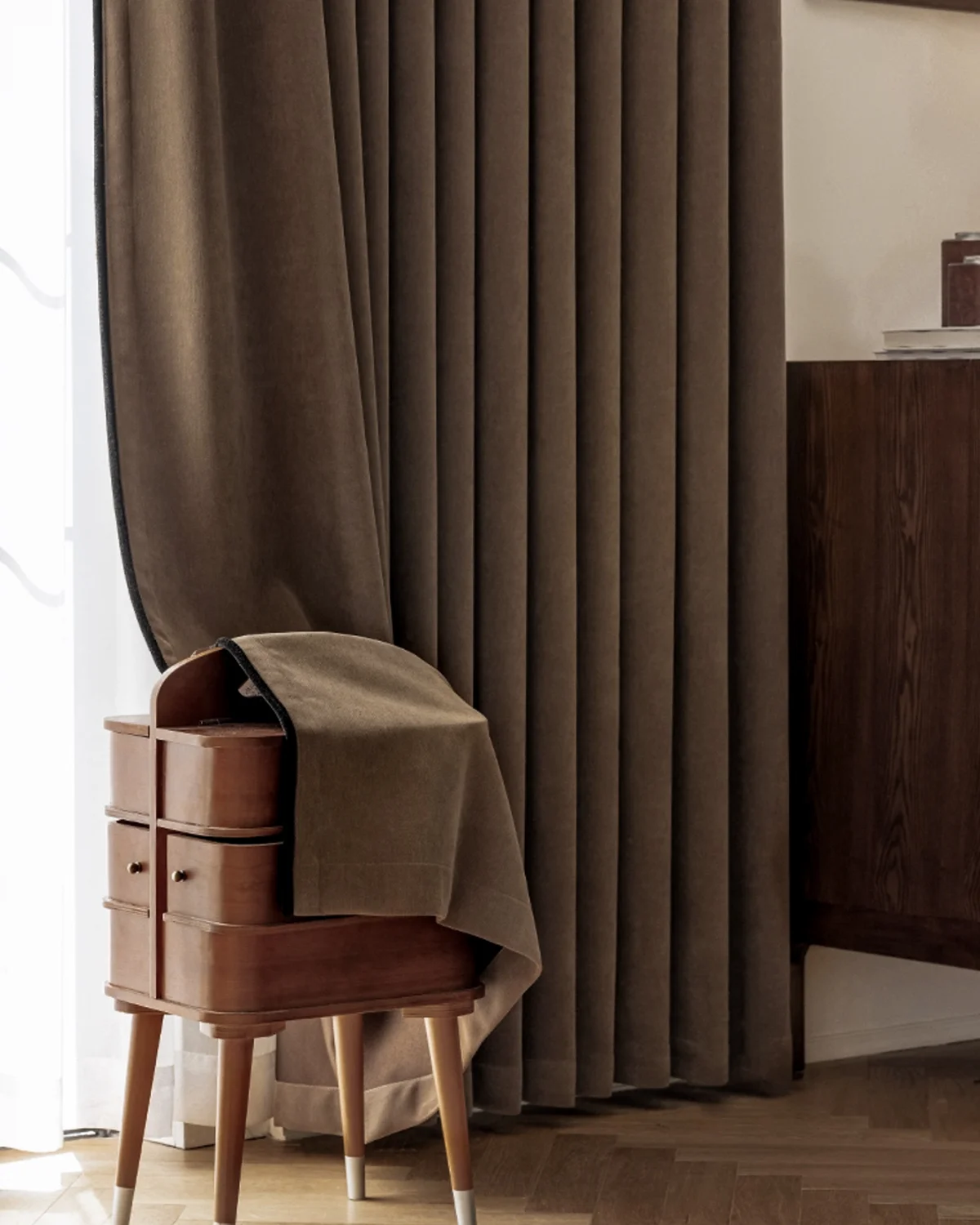 Mocha blackout curtain behind a wooden side table and chair in a cosy corner
