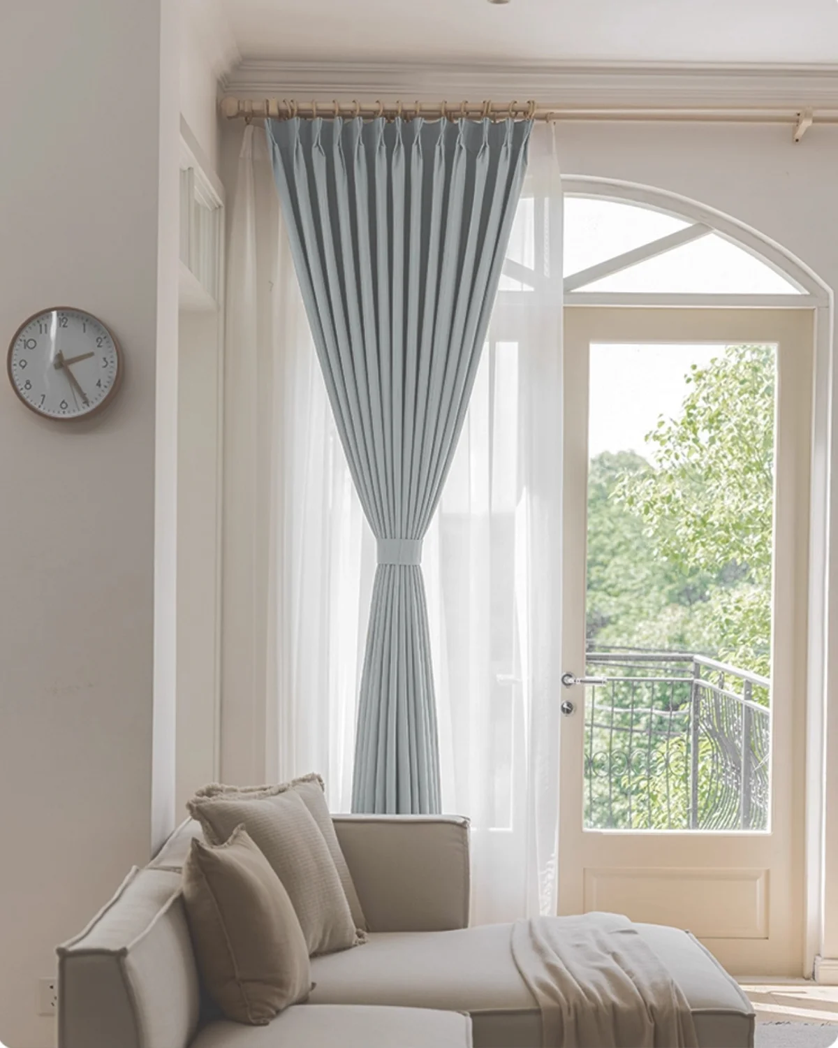 Cool grey blackout curtain tied back in a living room, showing soft pleats and full-length drape