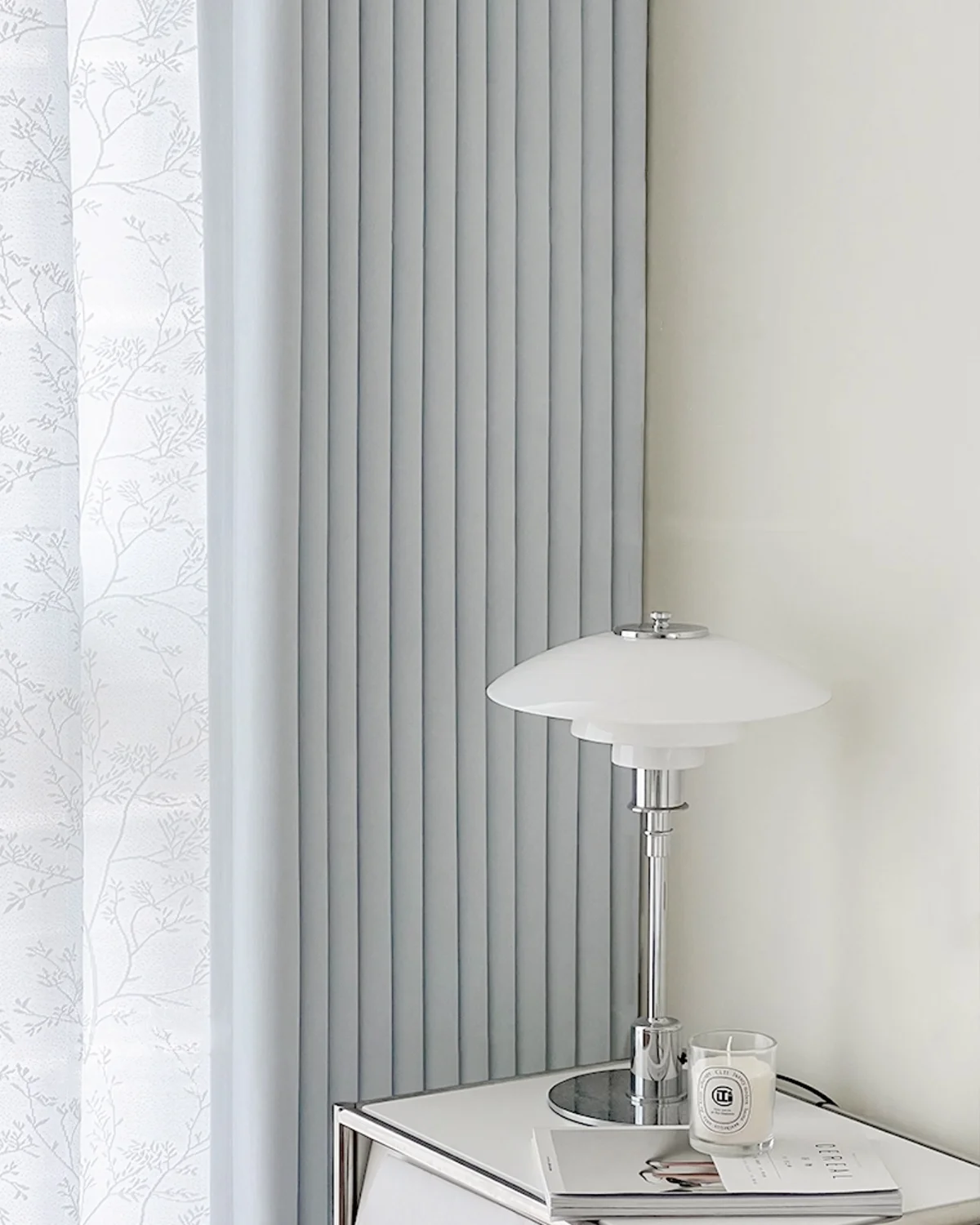 Cool grey blackout curtain in a bright minimalist room with a white table lamp