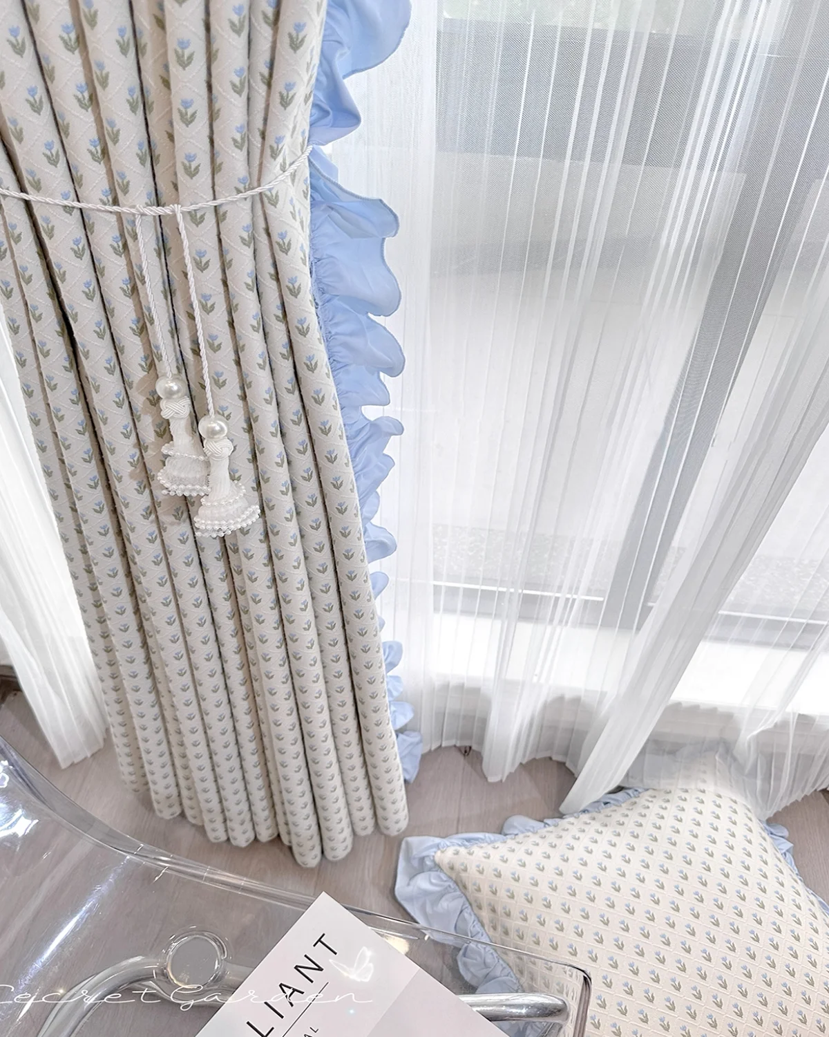 Embroidered sheer curtain layered with white sheers, showing petite floral pattern and pom pom trim