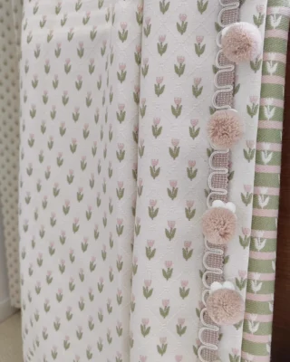 Embroidered sheer curtain close-up with petite floral repeat and pom pom trim edge