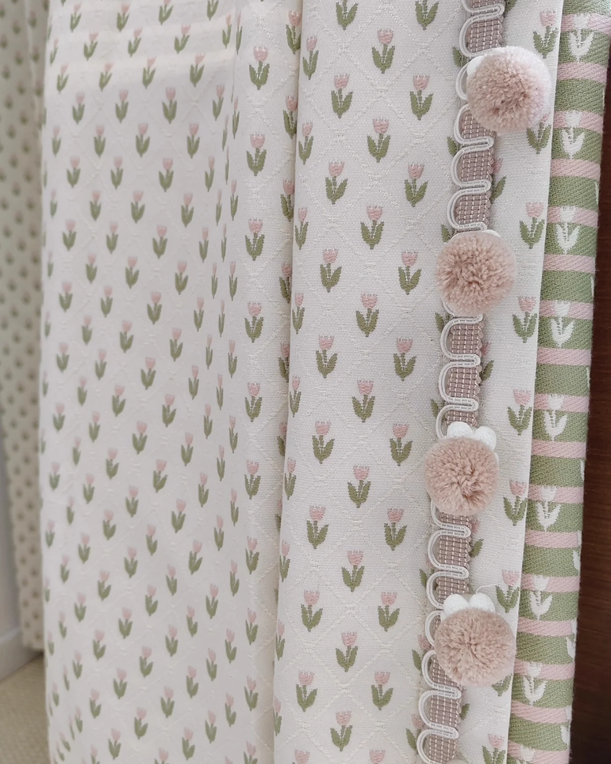 Embroidered sheer curtain close-up with petite floral repeat and pom pom trim edge