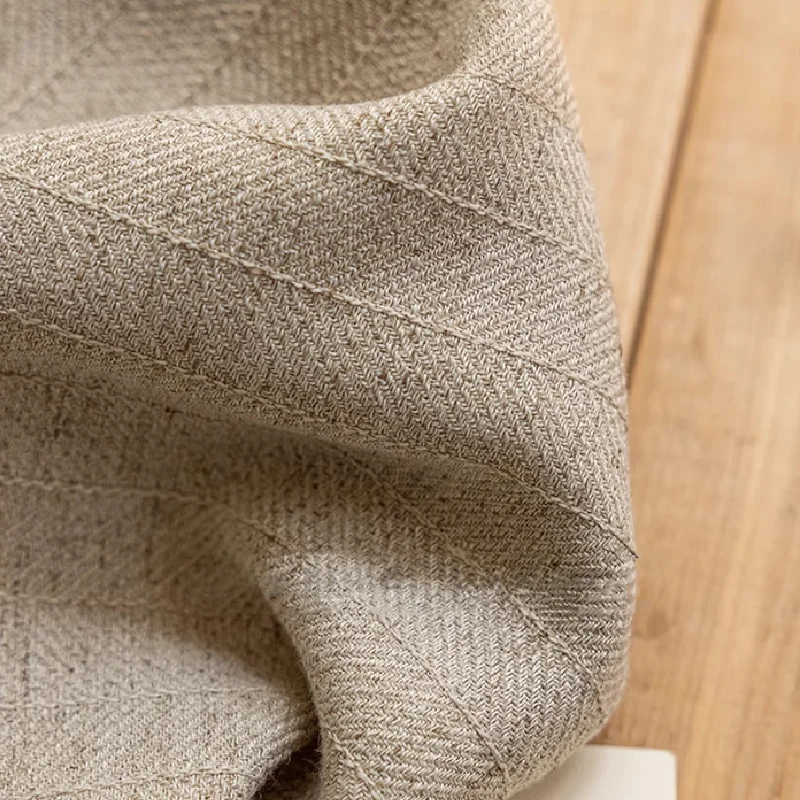 Beige linen fabric close-up showing natural plain weave texture.