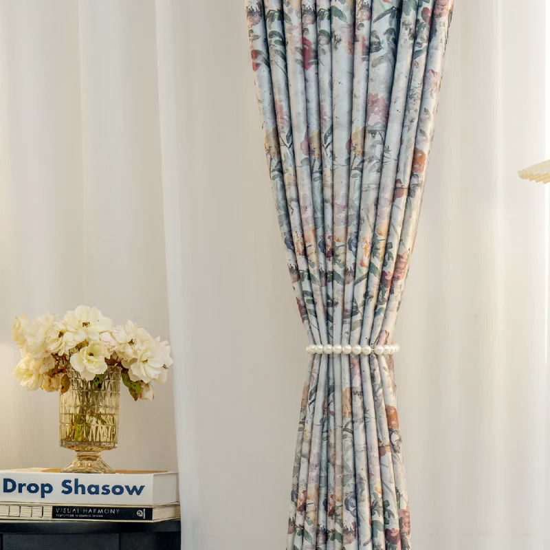 Front view of botanical print curtain tied back to show soft floral pattern and light-filtering effect.
