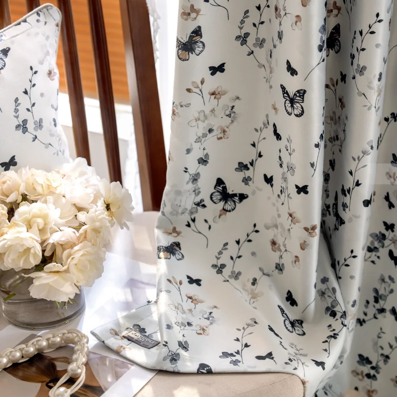 Butterfly print curtain hanging in natural light, with floral patterns and soft botanical details.