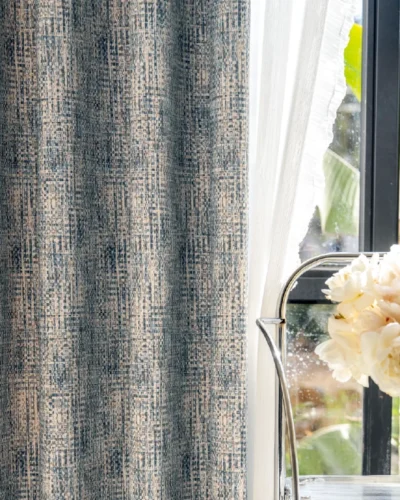Close-up of Woven Print Curtain in deep indigo and beige, showcasing faux textured print beside a bright window with flowers
