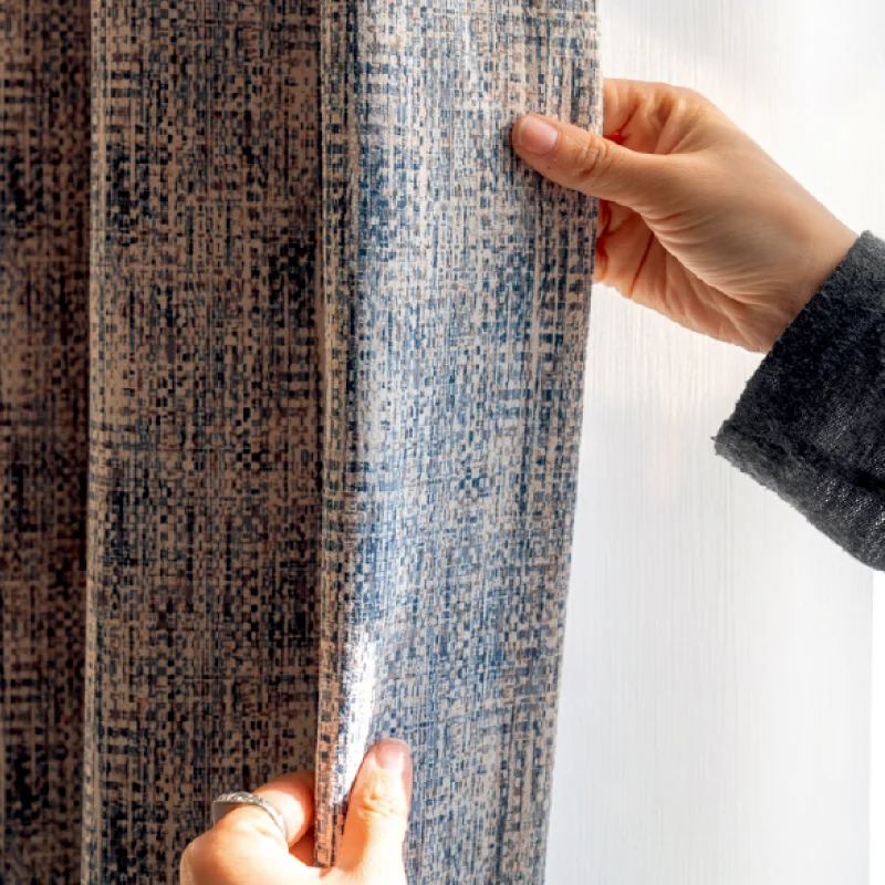 Hand touching Woven Print Curtain in indigo and beige, showing faux woven texture and soft drape