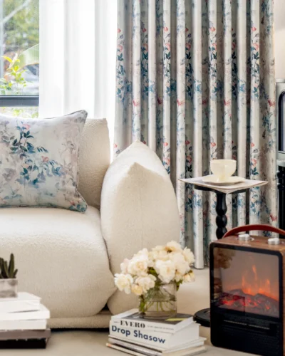 Watercolor floral curtain in soft blue and blush tones, styled in a modern living room with neutral sofa and floral décor – Dreamy Meadow collection.