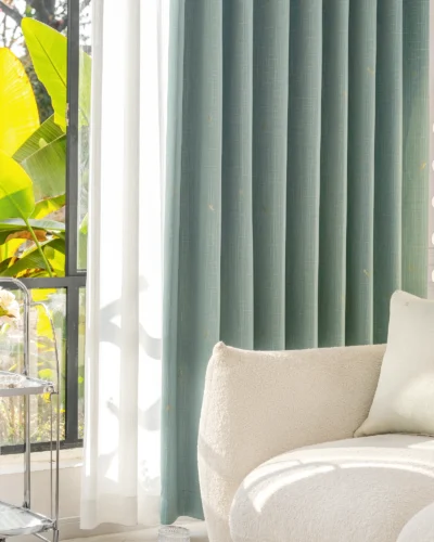 Living room with blue-grey dragonfly texture curtains and soft natural lighting.
