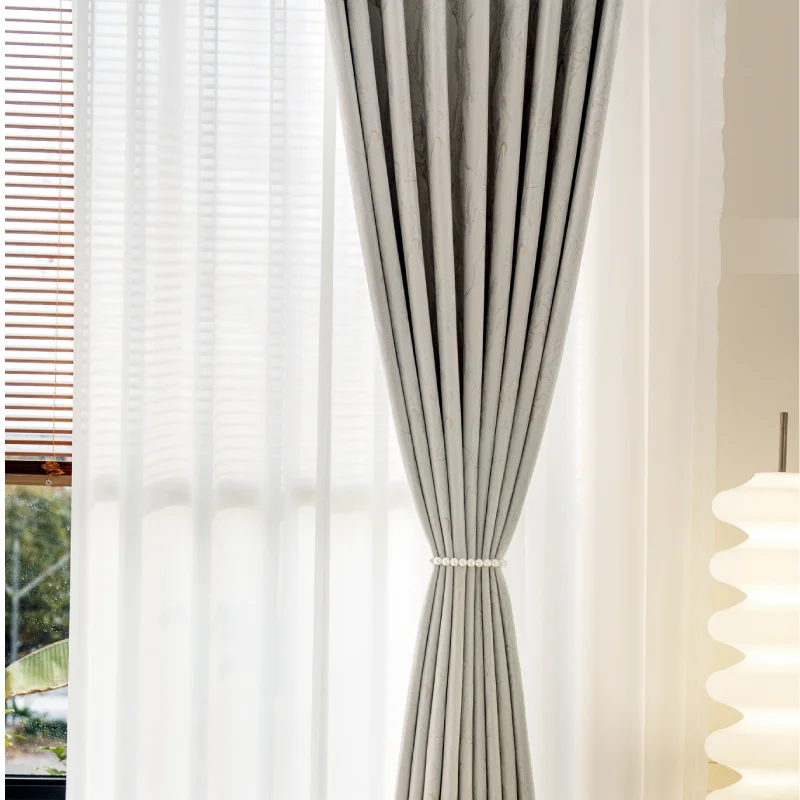 Ivory gold jacquard curtain with stone vein texture, tied back to reveal sheer white layer