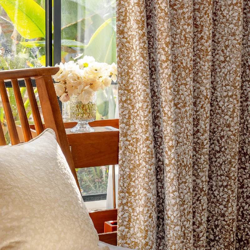 Brown printed curtain with dense floral patterns hanging by a wooden chair – Lemonhone