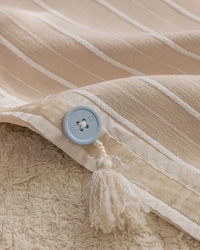 Close-up of Blush Sweet Curtain fabric showing striped jacquard texture with button detail.