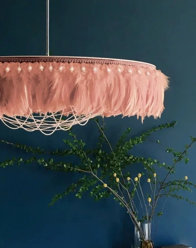 Pink feather and lace chandelier against deep blue wall