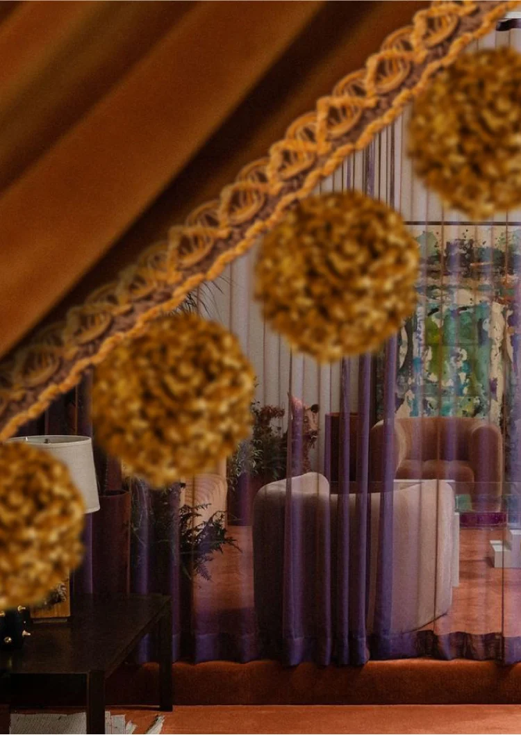 Golden pom pom fringe on luxurious drapery in a warm-toned living space