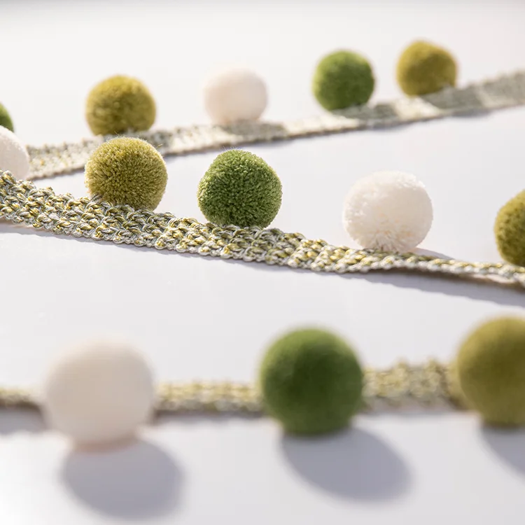 Close-up of green and ivory pom pom tassel trim – Eden series