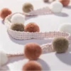 Color swatch of Eden Pom Tassel Trim – assorted pom pom colors in sample display